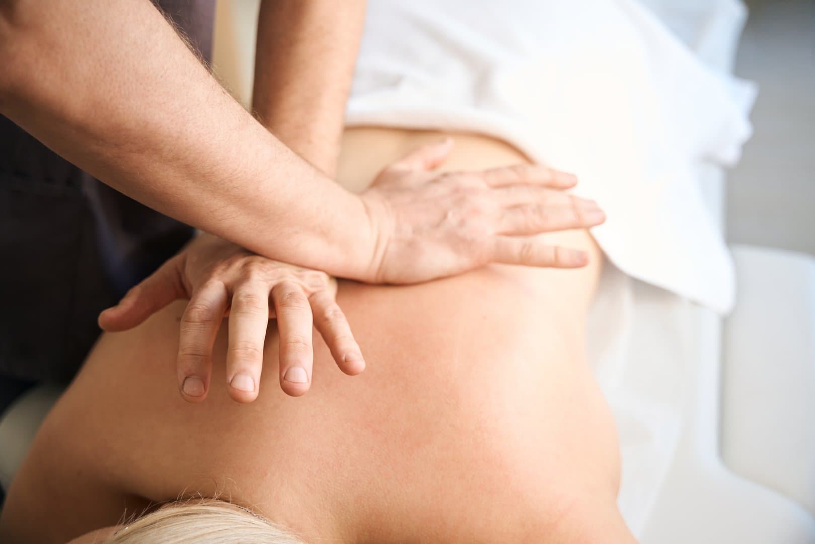 Fysiurgisk massage med tryk på musklerne langs rygsøjlen