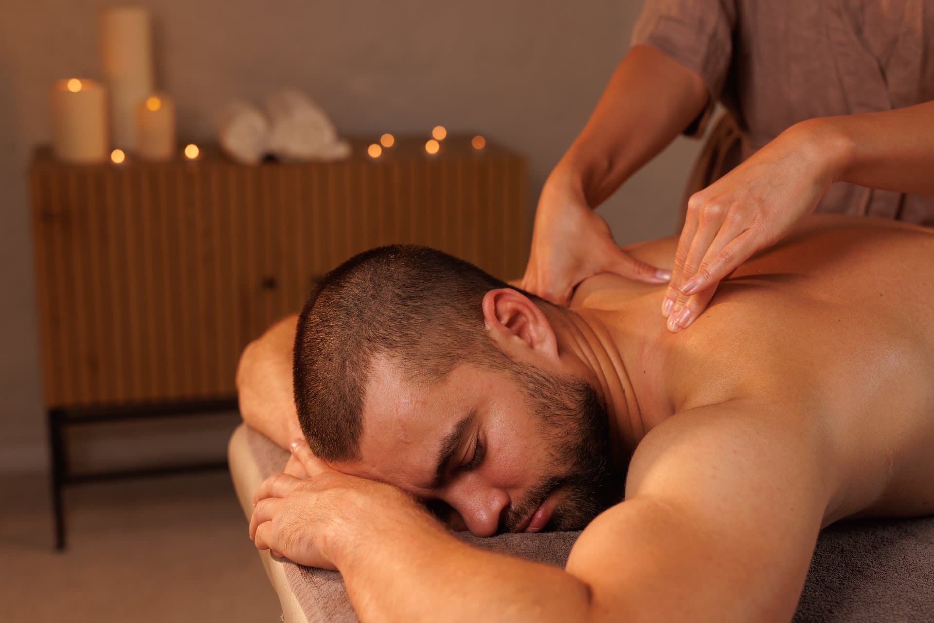 Massør giver en mand afspændende nakkemassage